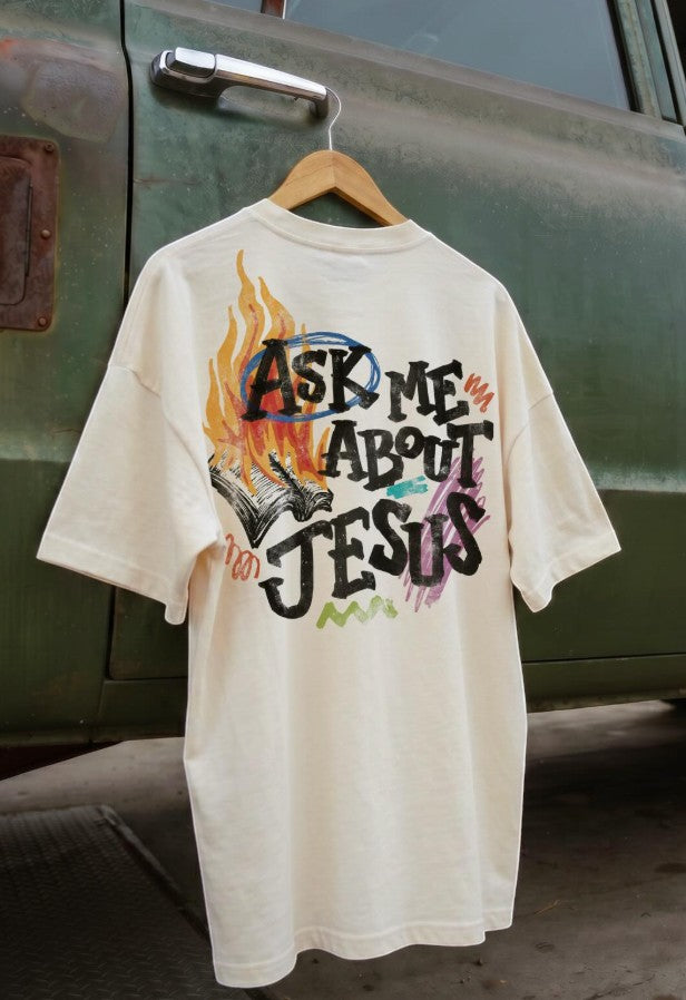 Revel cream 100% cotton graphic t-shirt with "Ask Me About Jesus" text and flame design on back. Short sleeves, crew neck.