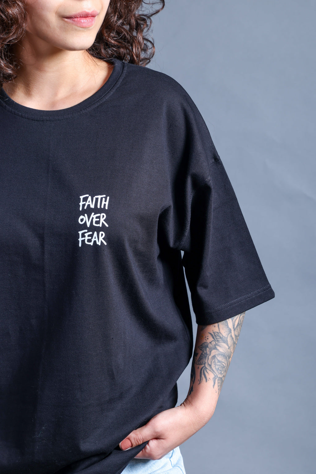 Revel black cotton t-shirt with white "Faith Over Fear" graphic print on chest. Crew neck, short sleeves.